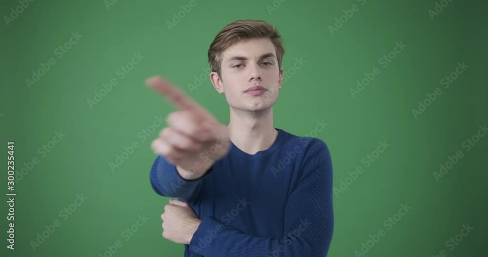 Upset young man gesturing no sign over green background Upset young man gesturing no sign over green background