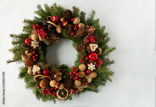 Obraz na płótnie Christmas decorative wreath of spruce braches with dried oranges, candles, cones, gingerbreads. Concept of Christmas preparation, atmosphere. Wishes card. Hand made wreath. Flat lay w salonie