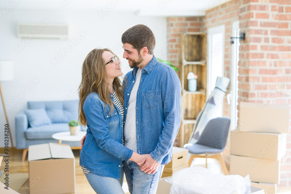 Young couple around cardboard boxes very happy moving to a new home Young couple around cardboard boxes very happy moving to a new home