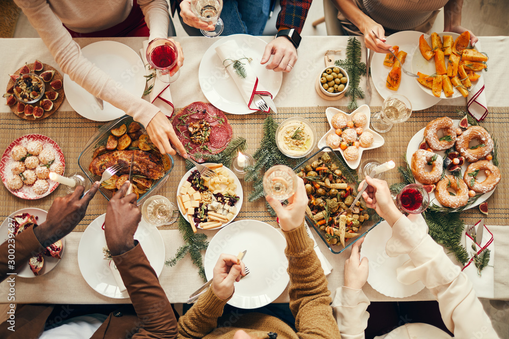 © Seventyfour - Top view background of people dining at festive Christmas table with delicious homemade food, copy space