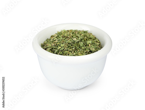 Bowl with dried parsley on white background