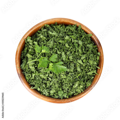 Bowl with dried parsley and fresh twig on white background, top view