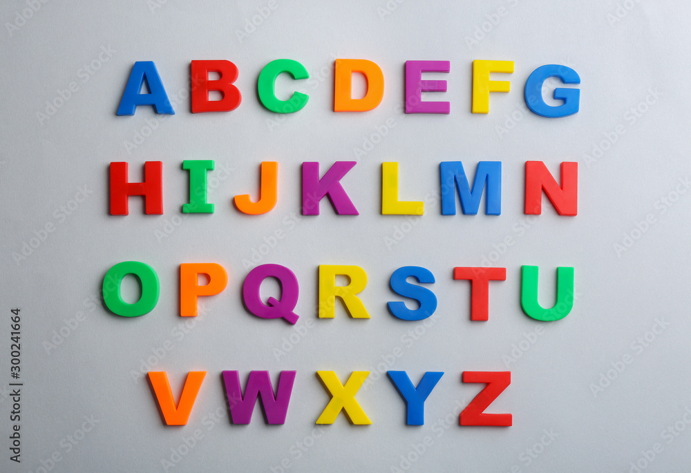 Plastic magnetic letters on grey background, flat lay. Alphabetical order
