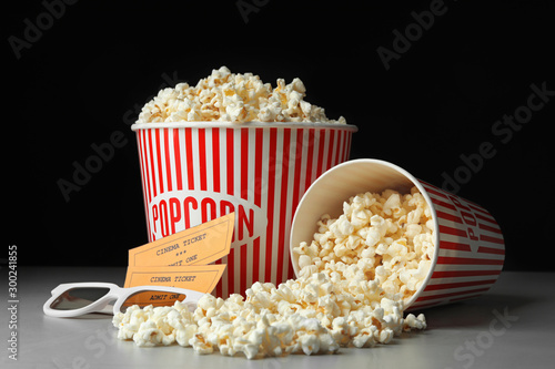 Popcorn, cinema tickets and 3d glasses on grey table