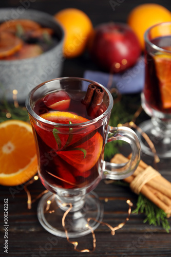 Tasty mulled wine with spices on wooden table