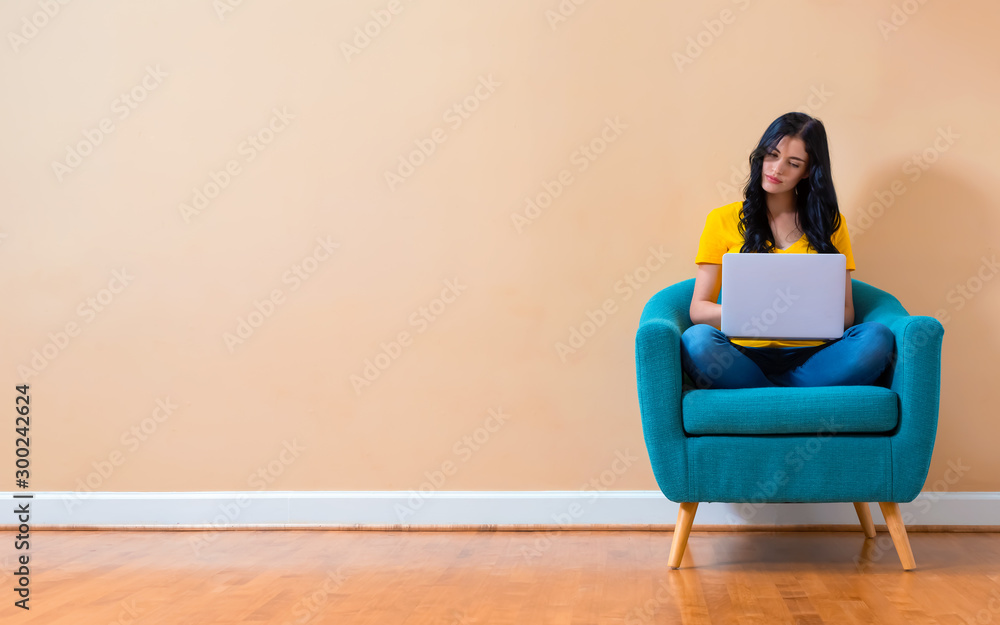 Young woman with a laptop computer sitting in a chair Young woman with a laptop computer sitting in a chair