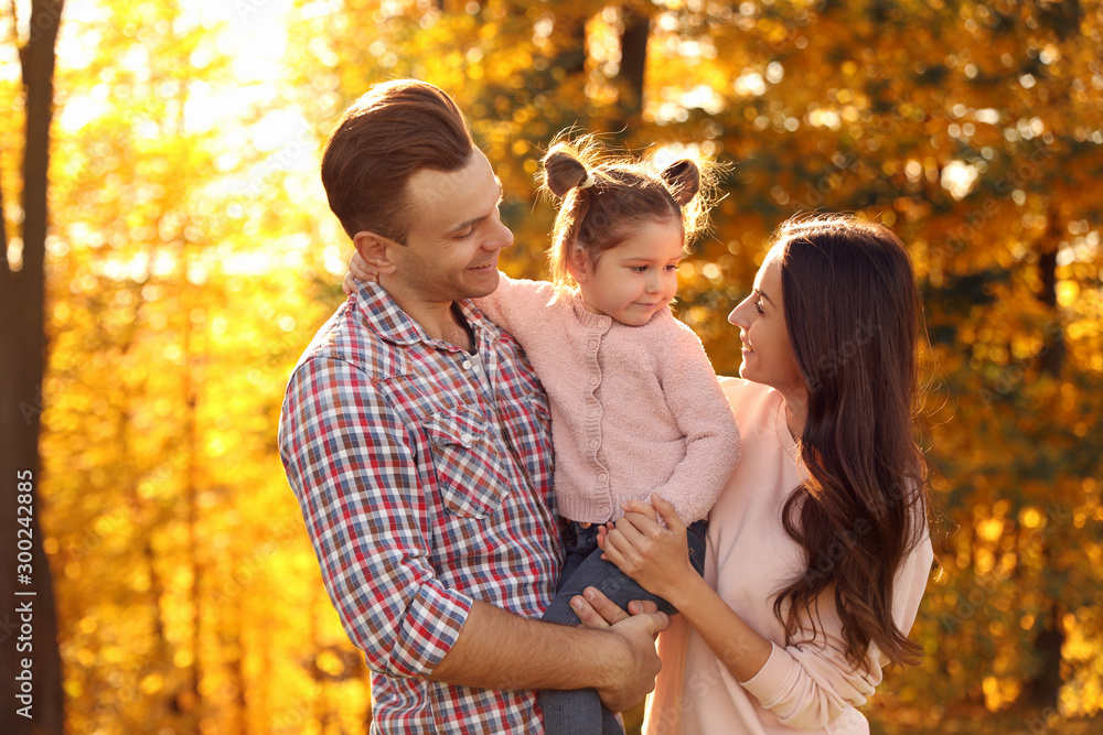 Happy family with little daughter in park. Autumn walk Happy family with little daughter in park. Autumn walk