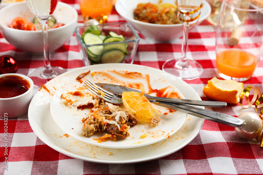 Food leftovers after party on table with checkered cloth, closeup