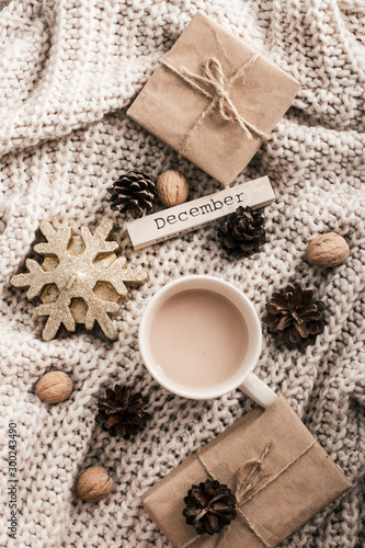 Winter composition. Coffee cup  candle  nuts and on sweater background.