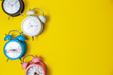 Flat lay of beautiful new alarm clock on yellow paper background