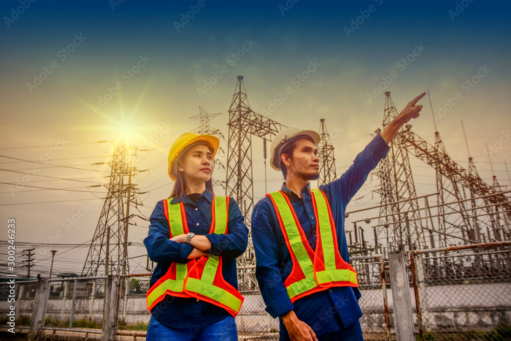 Fototapeta premium Two Engineer Standing at Work place Power plant Electric Factory plan System Sky Background