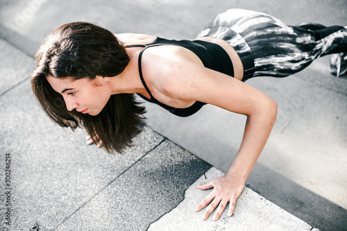 Beautiful sport fitness girl in sportswear doing fitness exercise in the street ,outdoor sports. Urban style.