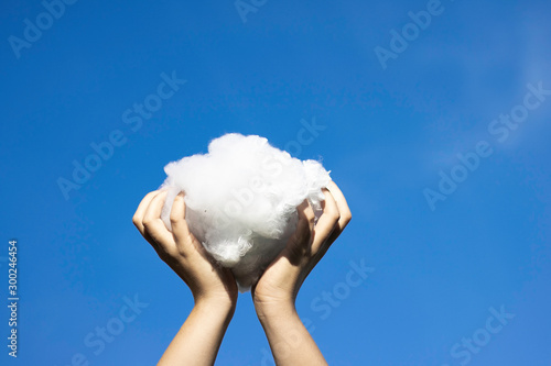 Hands holding cloud in sky