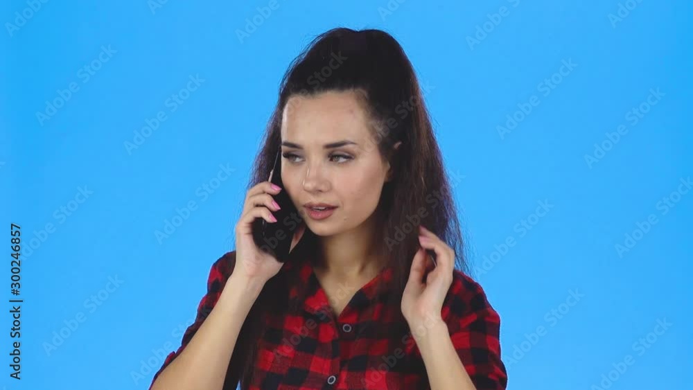 Young woman speaking by phone and smiling. Slow motion Young woman speaking by phone and smiling. Slow motion