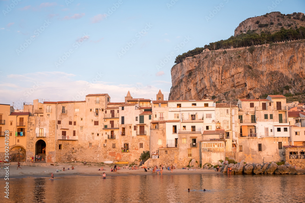 Seafront of Tyrrhenian Sea and Medieval houses of Sicilian coastal medieval city Cefalu in sunset