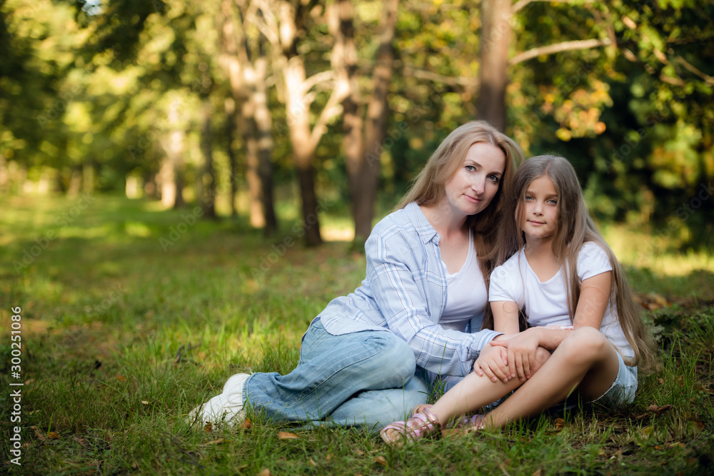 Mother and baby girl sitting and relaxing in park. Mother and baby girl sitting and relaxing in park.