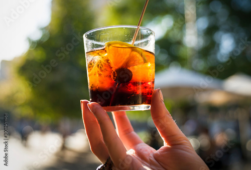 Slika na platnu This image capture shows a hand holding a glass of refreshing vermouth alcoholic