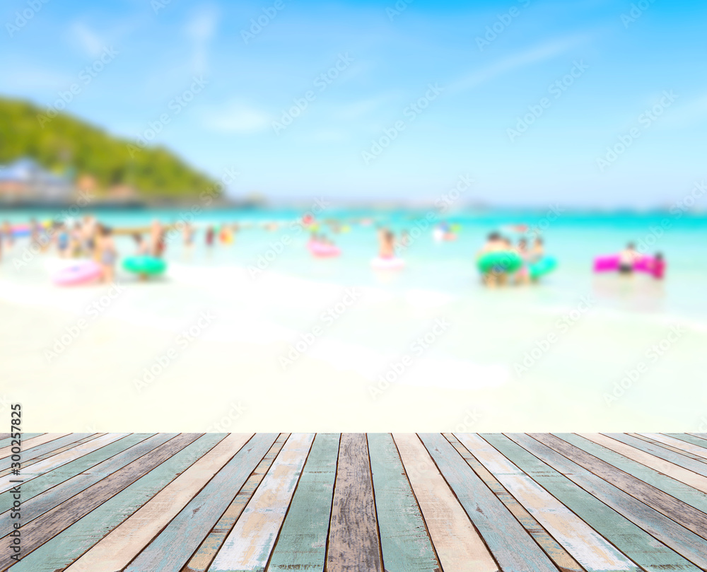 Wood table top with blurred people at the beach