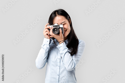 Young adult asian girl making photo on old camera