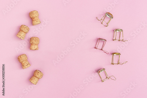 Corks and muselets from champagne sparkling wine on pink colored background with copy space. Christmas and Happy New Year concept. Flat lay.