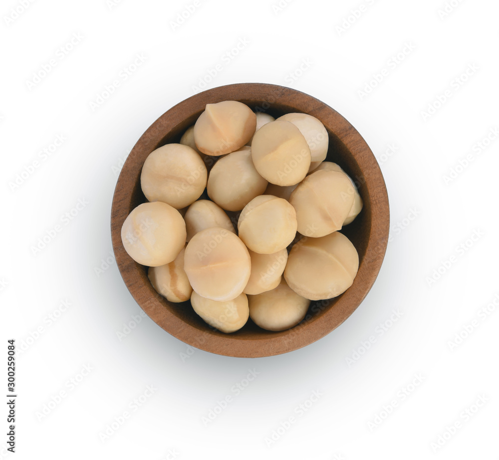 Macadamia nuts in wooden bowl on white background top view Macadamia nuts in wooden bowl on white background top view