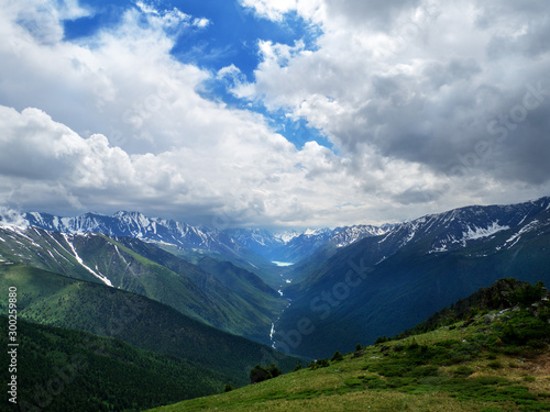 Mountainous landscape, lake and mountain range and river. Cloudy weather and panoramic view.