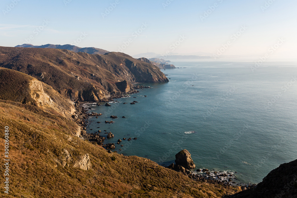Fototapeta premium Tennessee Valley Coastal Trail hike in Marin Headlands with views looking down Pacific Ocean coast toward San Francisco at sunset
