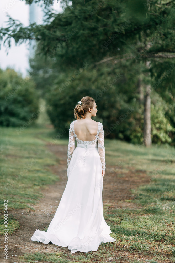 Elegant ceremony in European style. Beautiful bride in white flying dress in the forest.