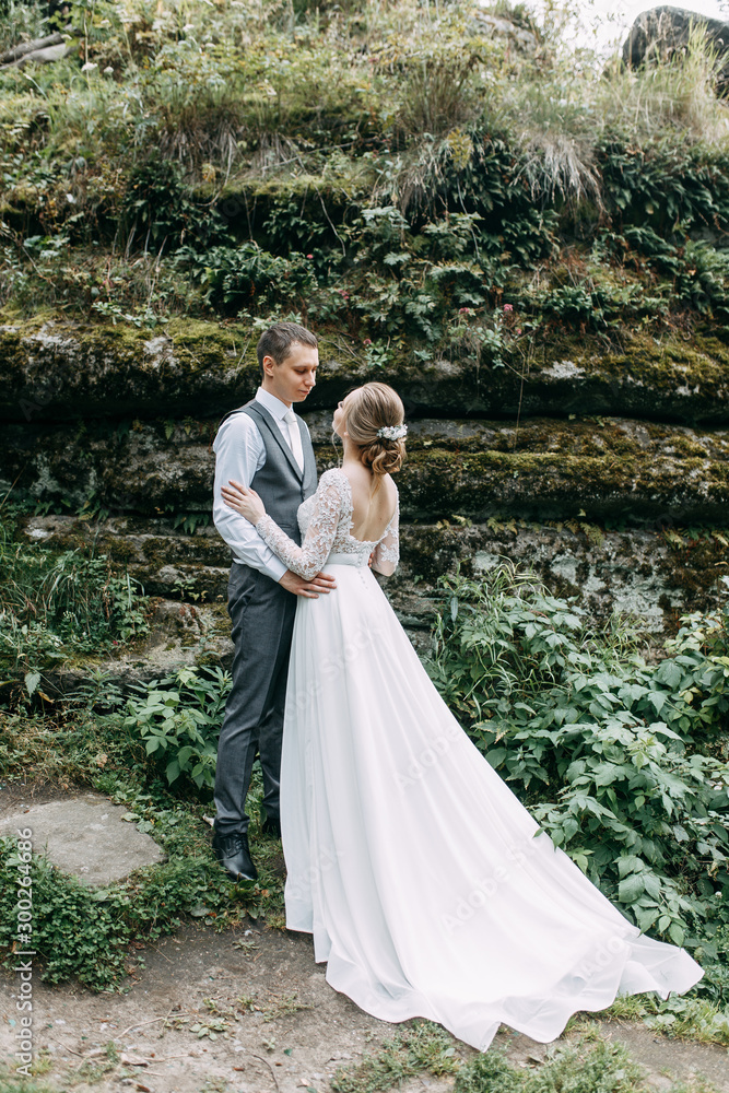 Modern ceremony in European style. Beautiful wedding couple in atmospheric forest with rocks. Modern ceremony in European style. Beautiful wedding couple in atmospheric forest with rocks.