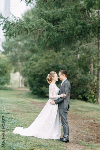 Modern ceremony in European style. Beautiful wedding couple in atmospheric forest with rocks.