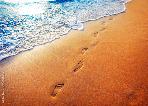 Fototapeta Naklejka Na Ścianę i Meble -  beach, wave and footprints at sunset time