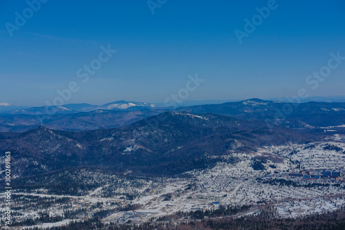 Winter landscape in Sheregesh. Frozen snow on trees. Frozen trees on a background of blue cloudy sky. A lot of snow fell in the winter cold in the mountains. Sunrise in the mountains