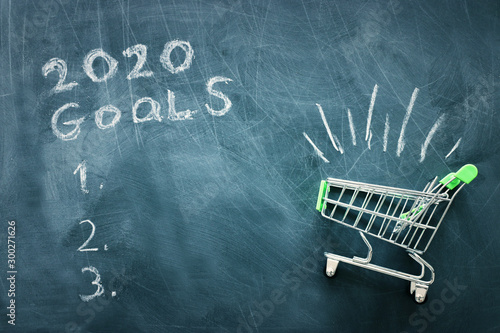 Business concept, top view of blackboard with the phrase 2020 goals and shopping cart