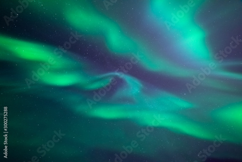 Stunning aurora borealis. Shape of fast mooving lights of crown aurora. Looking directly up in the sky. Northern ligths, green purple and blue colors. Tromso, Norway.