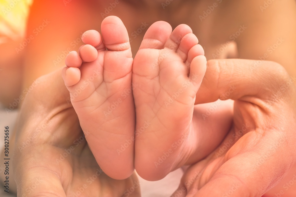 Newborn baby feet in hands of mother Newborn baby feet in hands of mother