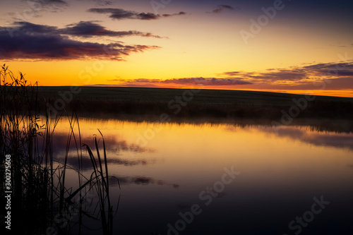 Vivid orange sunset reflected in a tranquil lake © NetPix