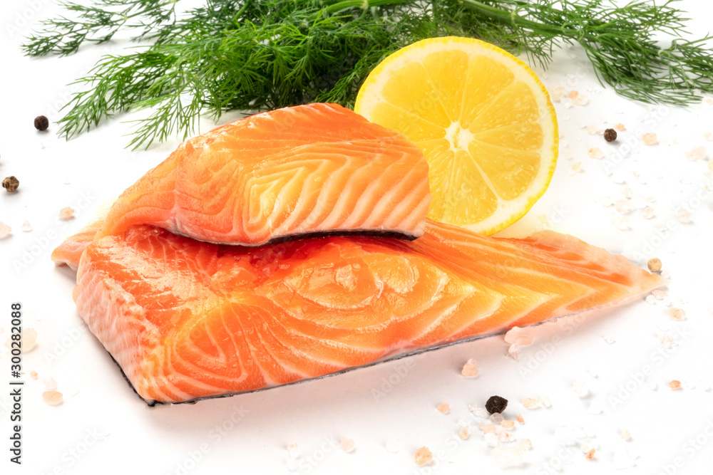 Slices of salmon with lemon and dill, close-up with salt and pepper, cooking fish, on a white background