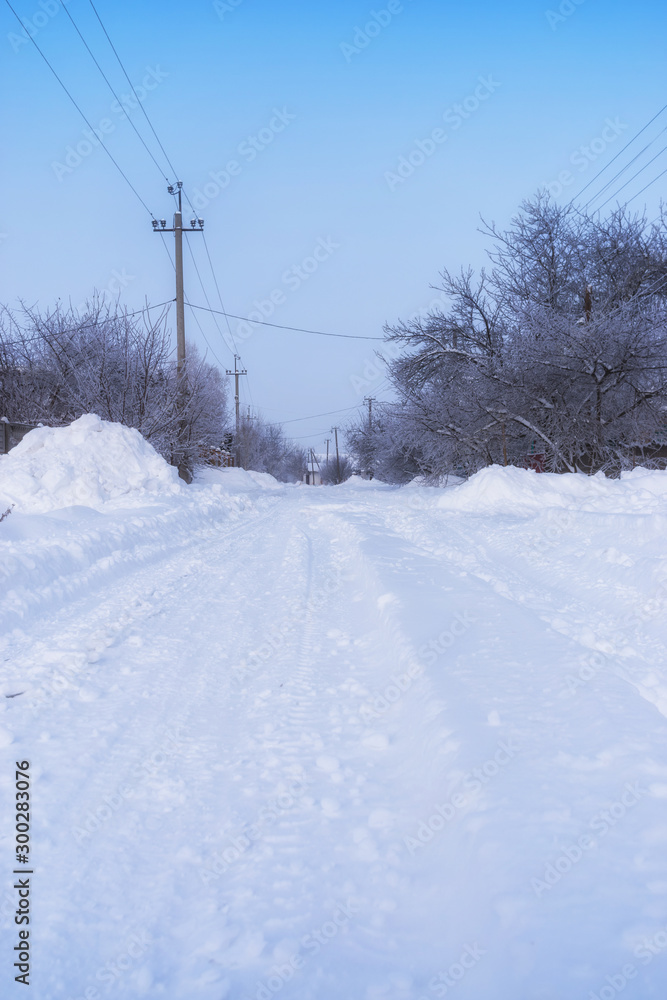 Winter landscape. Rural street after heavy snow, white trees and a road Winter landscape. Rural street after heavy snow, white trees and a road