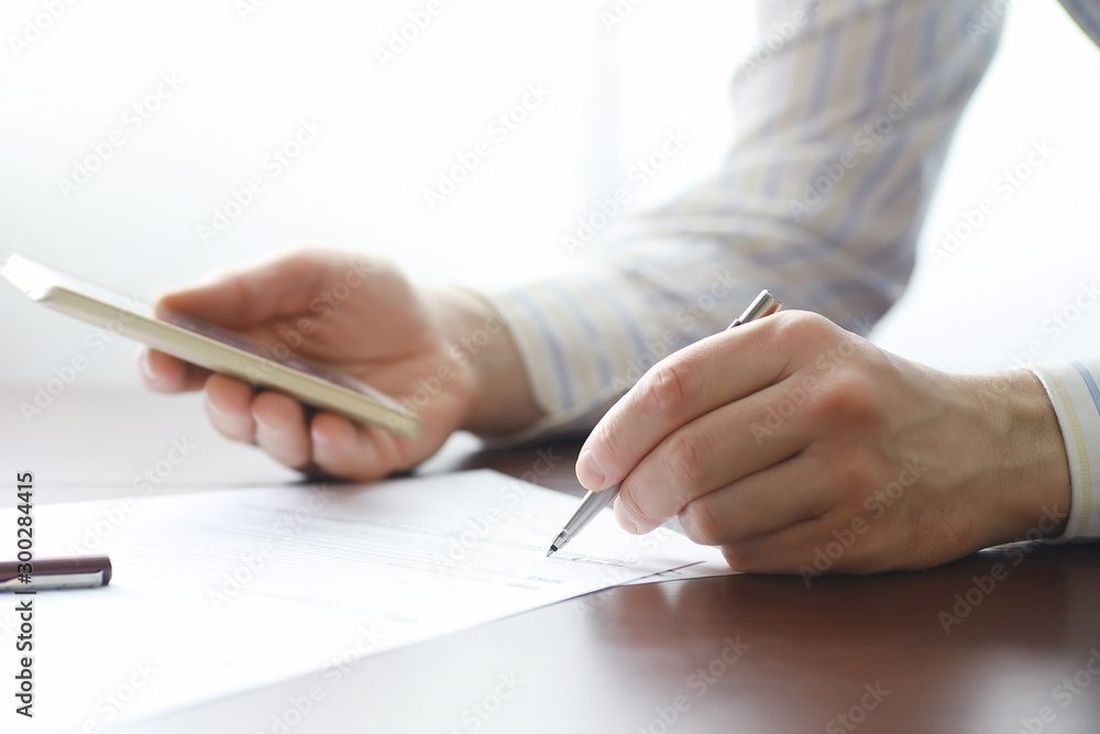 Business meeting. A man signs a contract. Male hand with pen makes notes in the office. Business meeting. A man signs a contract. Male hand with pen makes notes in the office.