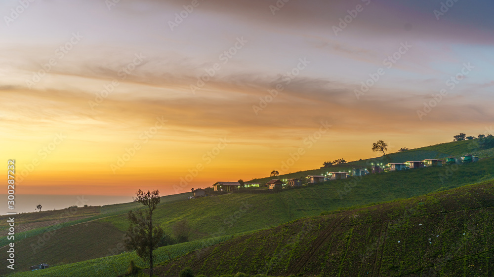 Landscape of village on hill with mountain sunrise time.