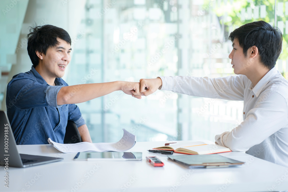 Young Businessmen make a fist bump after complete deal. Successful teamwork, partnership business concept. Young Businessmen make a fist bump after complete deal. Successful teamwork, partnership business concept.