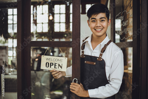 Wallpaper Mural Store owner turning open sign broad through the door glass and ready to service. Torontodigital.ca