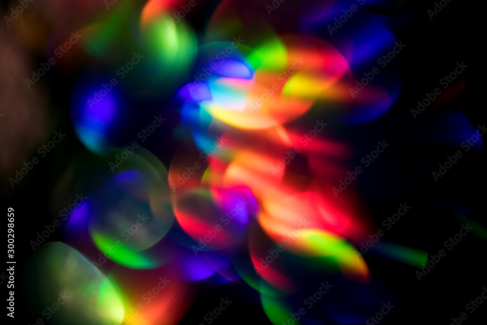 Abstract colorful glowing bokeh rainbow blur background on black