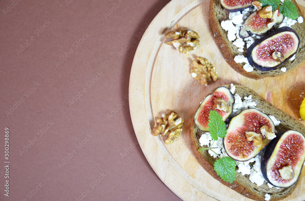 Sandwiches with ricotta, fresh figs, walnuts and honey. Canape or crostini with toasted baguette, cheese, jam, Delicious appetizer, ideal as an aperitif. Selective focus Sandwiches with ricotta, fresh figs, walnuts and honey. Canape or crostini with toasted baguette, cheese, jam, Delicious appetizer, ideal as an aperitif. Selective focus