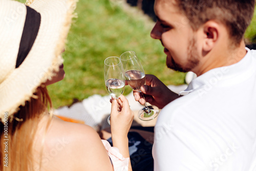 Beautiful girl in straw hat communicates with young attractive man and drinks wine photo