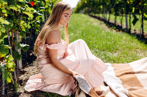 Beautiful young woman spreads out plaid for picnic photo