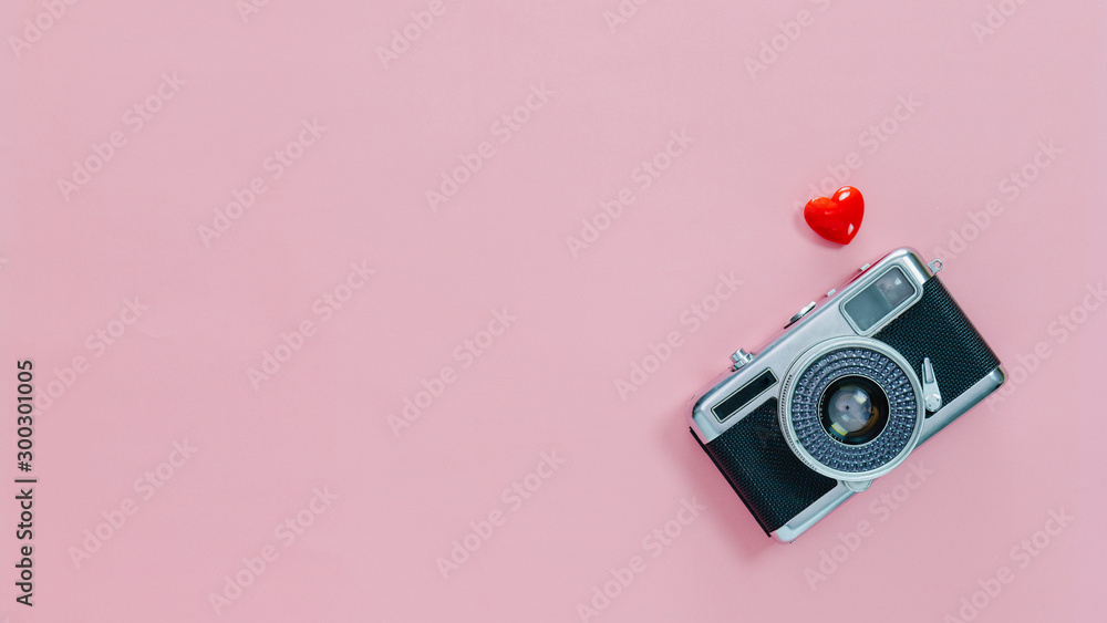 Top view of vintage old camera and little red heart on pink pastel background with empty space for text.Travel in holiday vacation with retro banner concept. - obrazy, fototapety, plakaty 