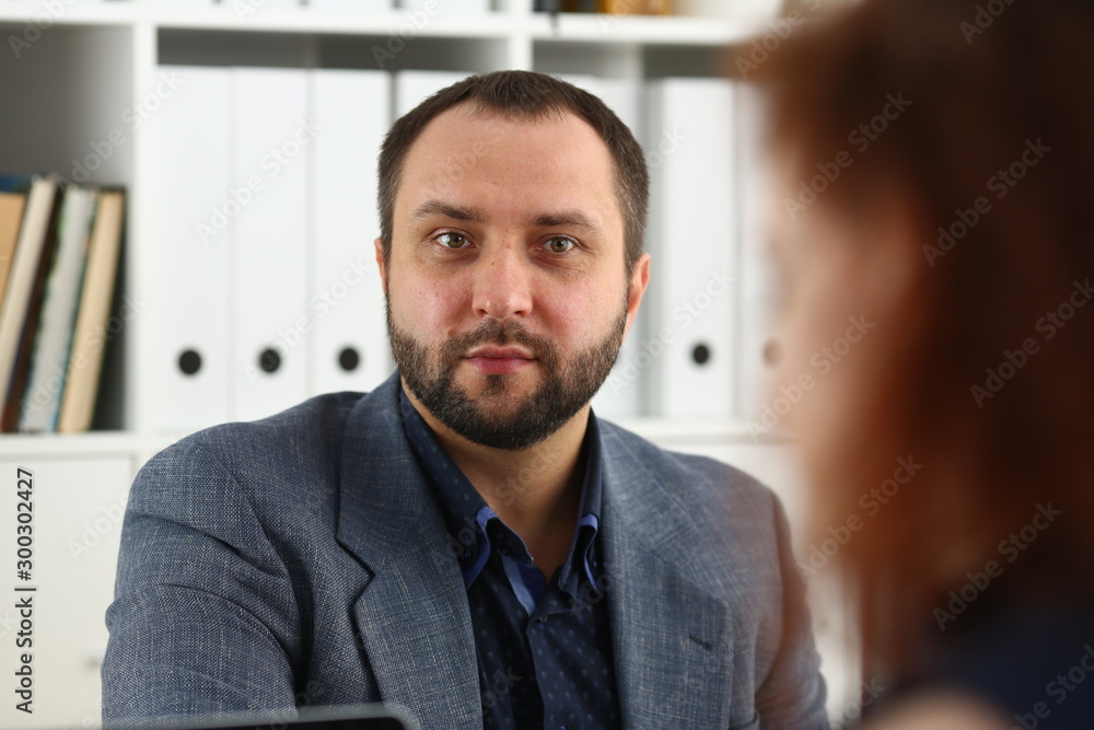 Naklejka premium young beautiful red haired woman sit at table in office in cabinet of her boss