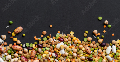 Colorful mixed legumes and cereals on black background. photo