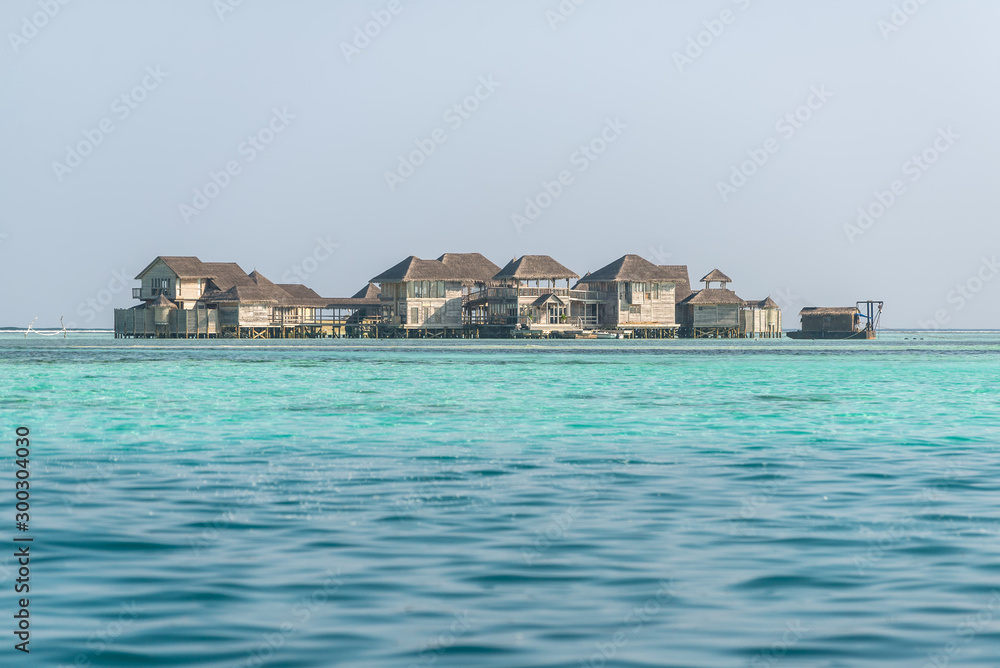 Water bungalows and blue turquoise sea in a tropical paradise island in Maldives